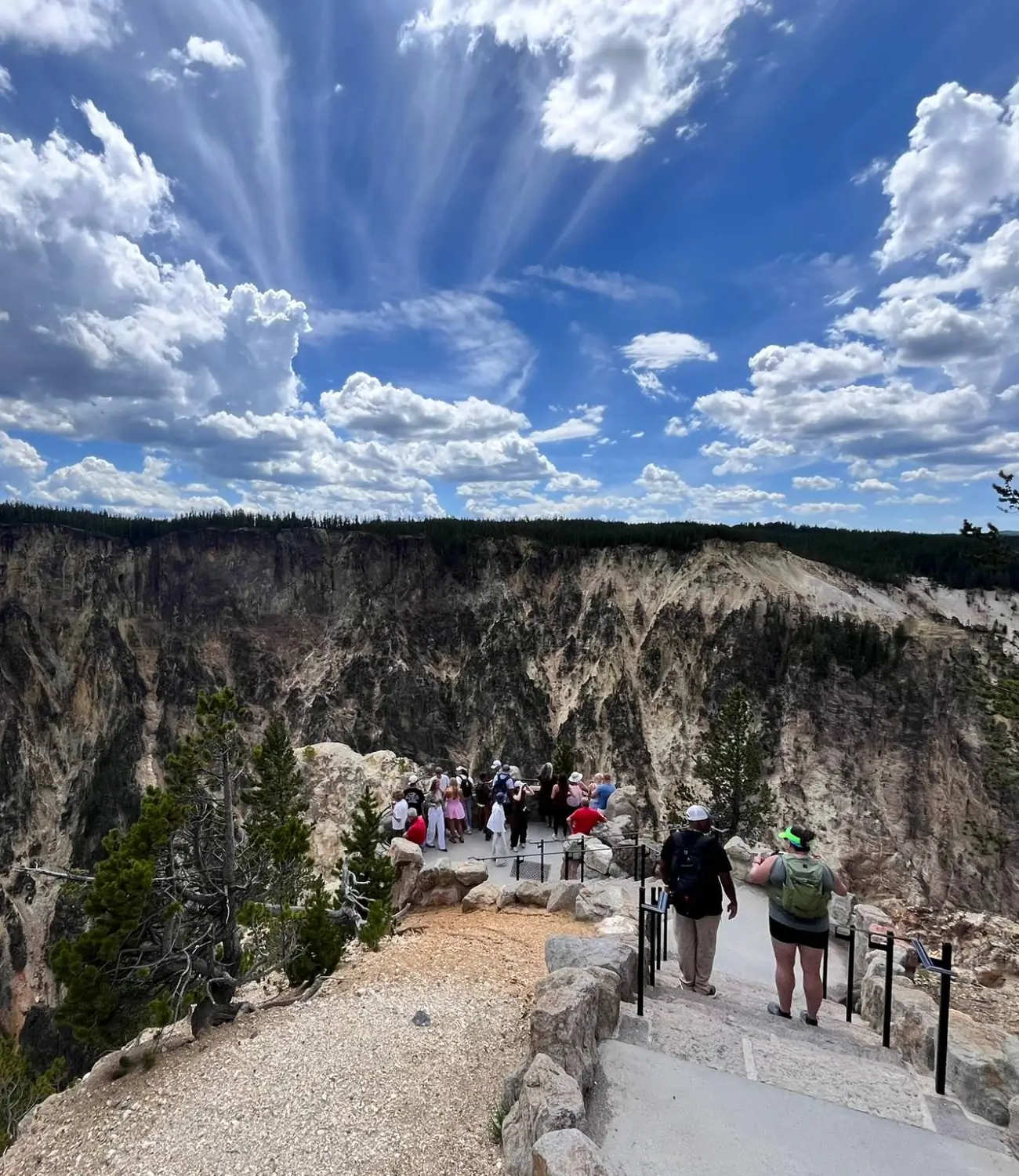 Hikers at a canyon overlook under a dramatic sky
