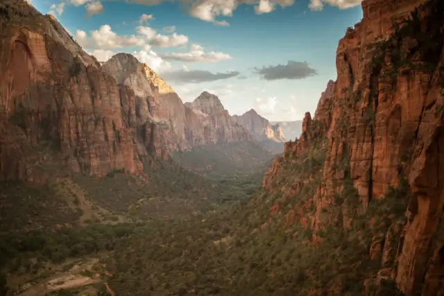 Red sandstone walls of Zion Canyon under a bright sky in Zion National Park