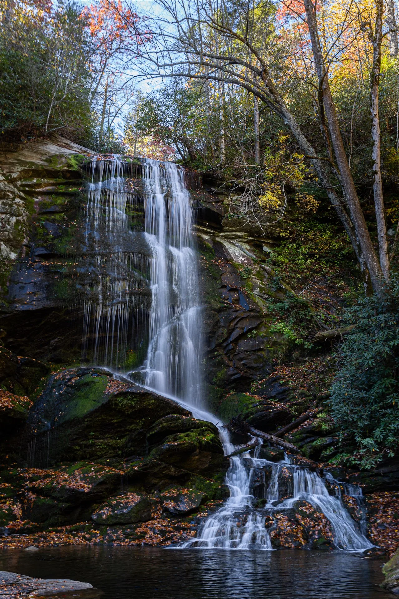 A waterfall cascades through autumn woodland in the Blue Ridge Mountains near Asheville